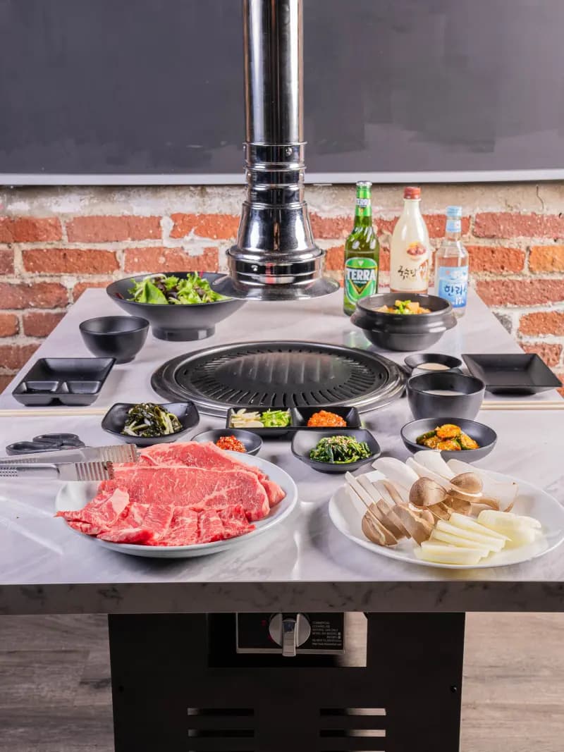 Commercial Korean BBQ grill and roaster with exhaust hood at Los Angeles restaurant